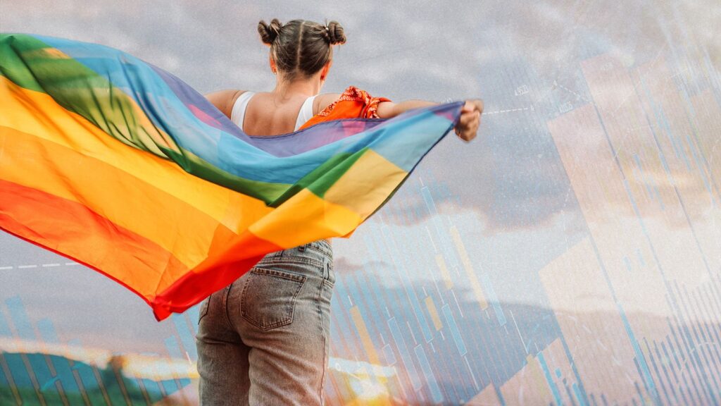 Mujer alzando la bandera del colectivo por la espalda